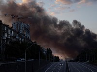 Kepulan asap membubung di atas kota saat sebuah mobil melaju di jalan raya setelah serangan rudal Rusia, di tengah serangan Rusia terhadap Ukraina, di Kyiv, Ukraina, 19 Juli 2026. (REUTERS/Thomas Peter)