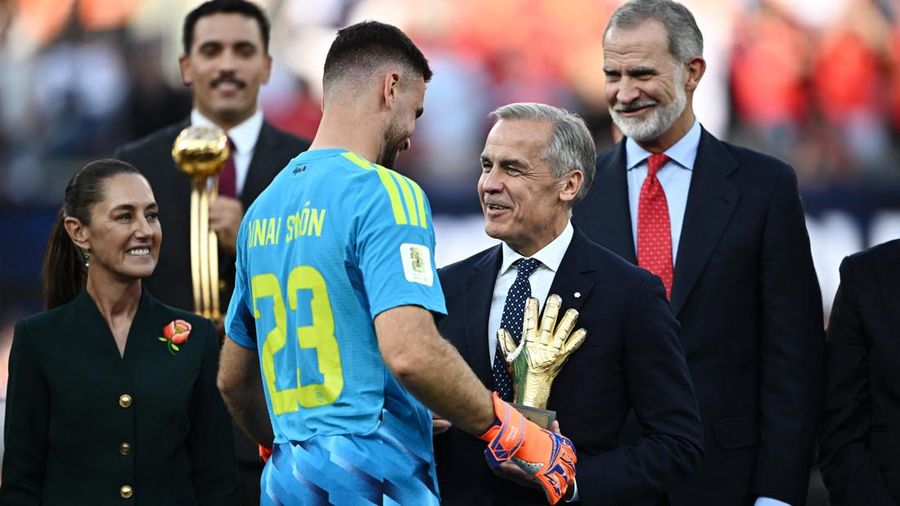 Kiper Spanyol Unai Simon berjabat tangan dengan Perdana Menteri Kanada Mark Carney usai menerima penghargaan Sarung Tangan Emas (Golden Glove), sementara Presiden Meksiko Claudia Sheinbaum menyaksikan seremoni tersebut pada final Piala Dunia FIFA 2026 di New York/New Jersey Stadium, East Rutherford, New Jersey, Amerika Serikat, Minggu (19/7/2026).