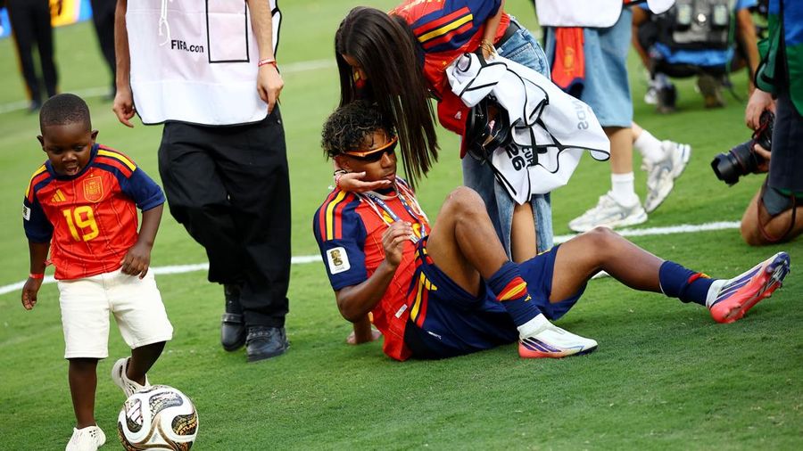 Lamine Yamal merayakan keberhasilan Spanyol menjuarai Piala Dunia FIFA 2026, sementara adiknya, Keyne Yamal, bermain sepak bola di lapangan usai seremoni penyerahan trofi di New York/New Jersey Stadium, East Rutherford, New Jersey, Amerika Serikat, M