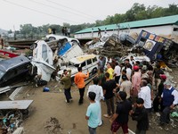 Orang-orang berkumpul di samping kendaraan yang bertumpuk setelah banjir bandang di Rajouri, Kashmir India, 19 Juli 2026. (REUTERS/Stringer)