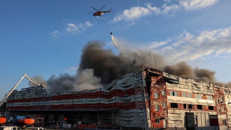 Sebuah helikopter pemadam kebakaran menjatuhkan air ke lokasi serangan rudal Rusia, di tengah serangan Rusia terhadap Ukraina, di wilayah Kyiv, Ukraina, 19 Juli 2026.