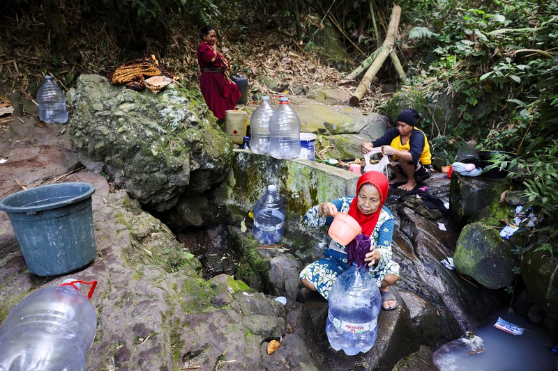 Penduduk desa mengumpulkan air mata air di daerah yang dilanda kekeringan selama musim kemarau, di tengah perkiraan bahwa El Ni&ntilde;o dapat menyebabkan kondisi yang lebih kering dari biasanya, di desa Gunung Batur, Cilegon. (REUTERS/Ajeng Dinar Ulfiana)