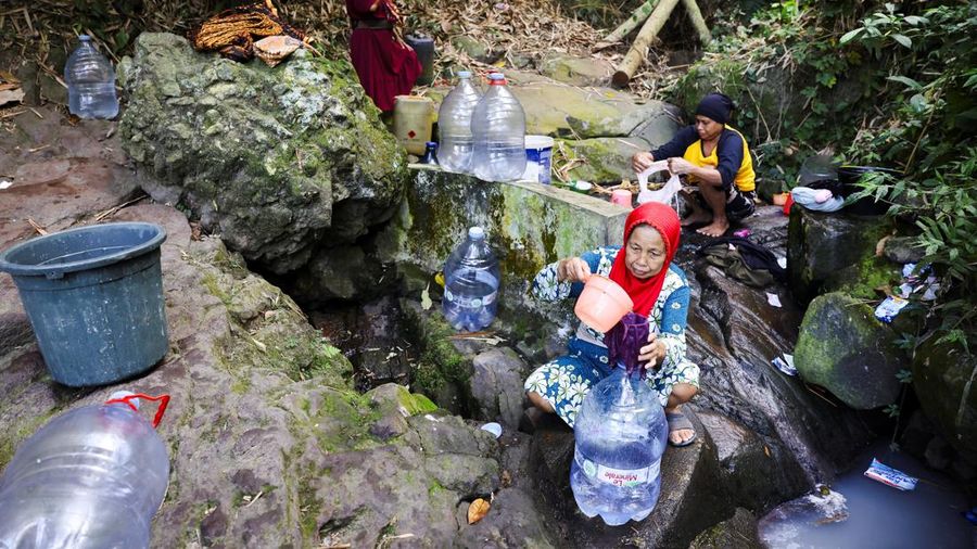 Penduduk desa mengumpulkan air mata air di daerah yang dilanda kekeringan selama musim kemarau, di tengah perkiraan bahwa El Niño dapat menyebabkan kondisi yang lebih kering dari biasanya, di desa Gunung Batur, Cilegon. (REUTERS/Ajeng Dinar Ulfiana)