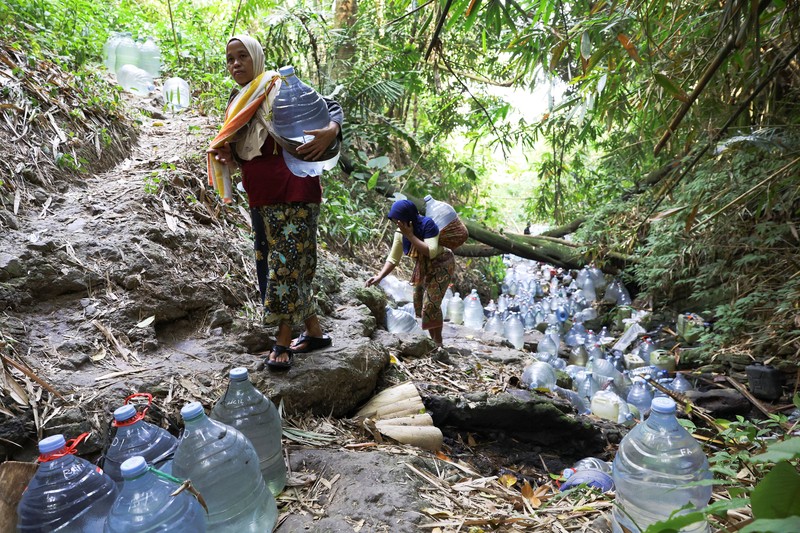 Penduduk desa mengumpulkan air mata air di daerah yang dilanda kekeringan selama musim kemarau, di tengah perkiraan bahwa El Ni&ntilde;o dapat menyebabkan kondisi yang lebih kering dari biasanya, di desa Gunung Batur, Cilegon. (REUTERS/Ajeng Dinar Ulfiana)