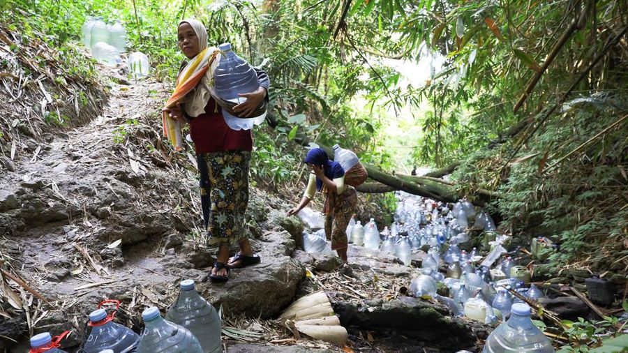 Penduduk desa mengumpulkan air mata air di daerah yang dilanda kekeringan selama musim kemarau, di tengah perkiraan bahwa El Niño dapat menyebabkan kondisi yang lebih kering dari biasanya, di desa Gunung Batur, Cilegon. (REUTERS/Ajeng Dinar Ulfiana)