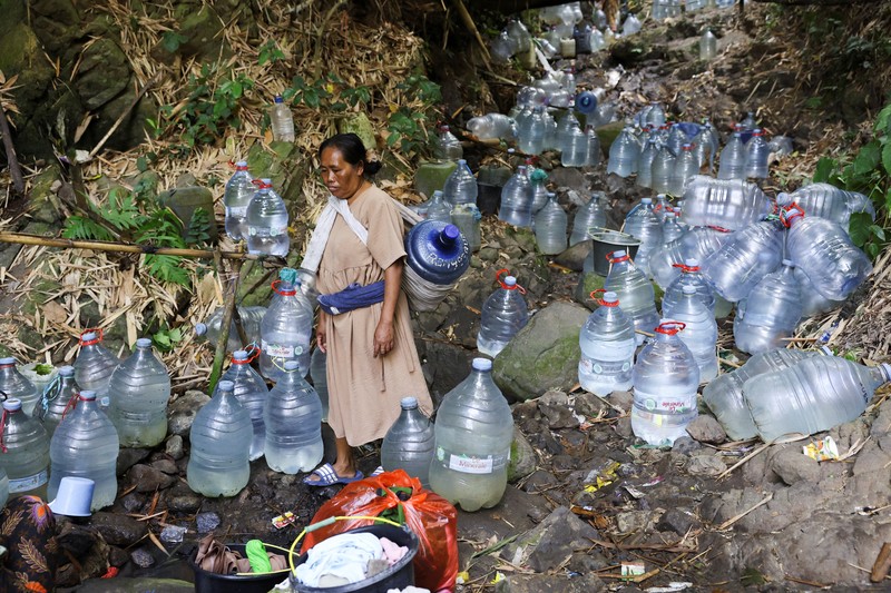Penduduk desa mengumpulkan air mata air di daerah yang dilanda kekeringan selama musim kemarau, di tengah perkiraan bahwa El Ni&ntilde;o dapat menyebabkan kondisi yang lebih kering dari biasanya, di desa Gunung Batur, Cilegon. (REUTERS/Ajeng Dinar Ulfiana)