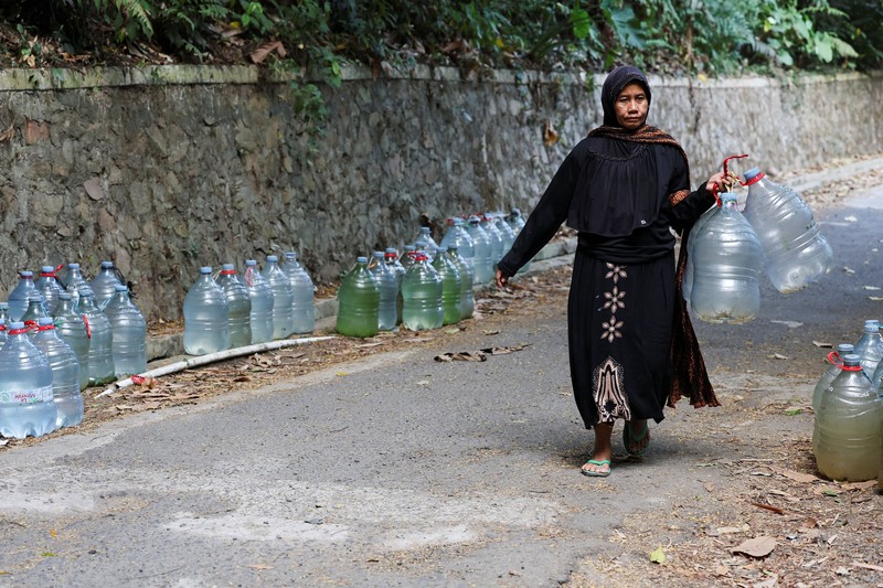 Penduduk desa mengumpulkan air mata air di daerah yang dilanda kekeringan selama musim kemarau, di tengah perkiraan bahwa El Ni&ntilde;o dapat menyebabkan kondisi yang lebih kering dari biasanya, di desa Gunung Batur, Cilegon. (REUTERS/Ajeng Dinar Ulfiana)