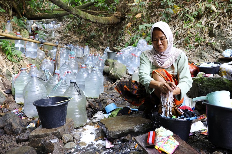 Penduduk desa mengumpulkan air mata air di daerah yang dilanda kekeringan selama musim kemarau, di tengah perkiraan bahwa El Ni&ntilde;o dapat menyebabkan kondisi yang lebih kering dari biasanya, di desa Gunung Batur, Cilegon. (REUTERS/Ajeng Dinar Ulfiana)