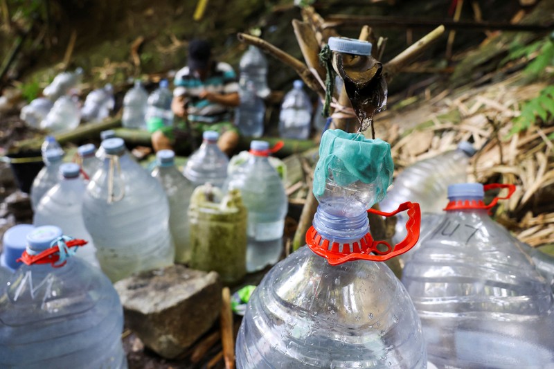 Penduduk desa mengumpulkan air mata air di daerah yang dilanda kekeringan selama musim kemarau, di tengah perkiraan bahwa El Ni&ntilde;o dapat menyebabkan kondisi yang lebih kering dari biasanya, di desa Gunung Batur, Cilegon. (REUTERS/Ajeng Dinar Ulfiana)