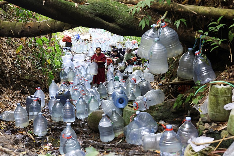 Penduduk desa mengumpulkan air mata air di daerah yang dilanda kekeringan selama musim kemarau, di tengah perkiraan bahwa El Ni&ntilde;o dapat menyebabkan kondisi yang lebih kering dari biasanya, di desa Gunung Batur, Cilegon. (REUTERS/Ajeng Dinar Ulfiana)