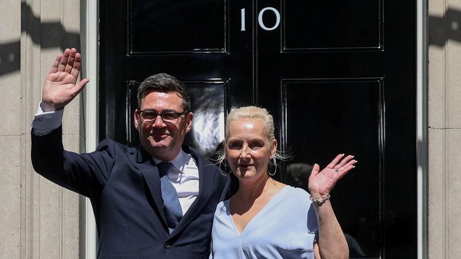 Perdana Menteri Inggris yang baru dilantik, Andy Burnham, melambaikan tangan di luar 10 Downing Street bersama istrinya, Marie-France van Heel, setelah resmi menjabat, di London, Inggris, 20 Juli 2026.