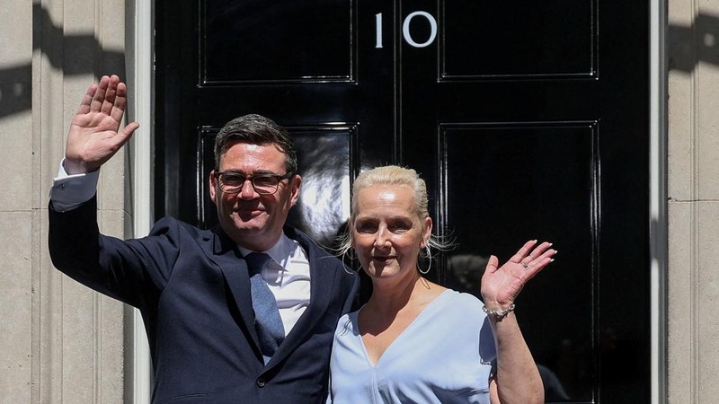 Perdana Menteri Inggris yang baru dilantik, Andy Burnham, melambaikan tangan di luar 10 Downing Street bersama istrinya, Marie-France van Heel, setelah resmi menjabat, di London, Inggris, 20 Juli 2026.