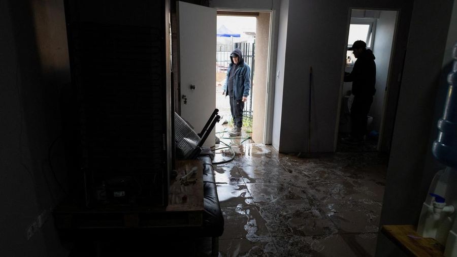 Santiago Ramirez dan saudaranya membersihkan rumah mereka setelah hujan deras akibat front cuaca yang menyebabkan banjir dan mendorong pihak berwenang Chili untuk menyatakan keadaan darurat preventif pada awal pekan ini, di Talagante, Chili, 18 Juli
