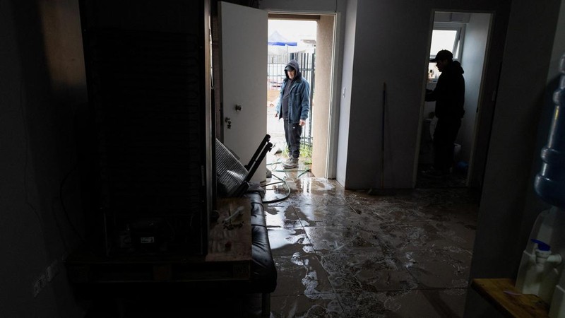 Santiago Ramirez dan saudaranya membersihkan rumah mereka setelah hujan deras akibat front cuaca yang menyebabkan banjir dan mendorong pihak berwenang Chili untuk menyatakan keadaan darurat preventif pada awal pekan ini, di Talagante, Chili, 18 Juli