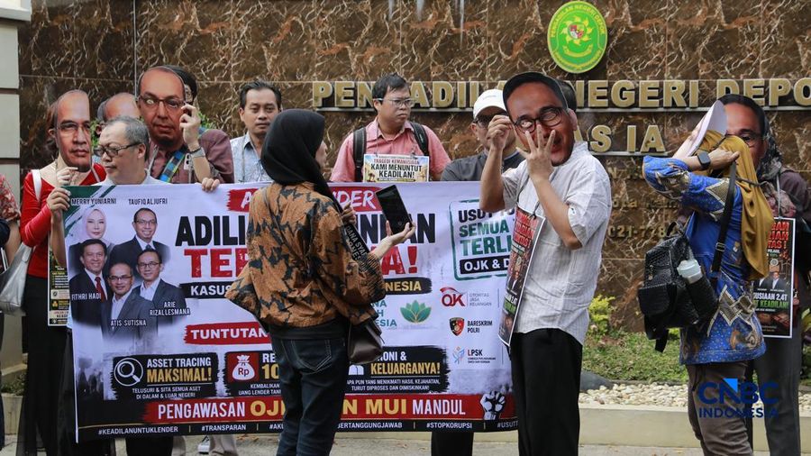 Lender DSI menggelar aksi damai di depan Pengadilan Negeri Depok sejak pagi sebelum persidangan dimulai. Mereka membawa berbagai spanduk dan poster berisi tuntutan agar proses hukum berjalan transparan serta memberikan kepastian bagi para korban, Rabu (22/7/2026). (CNBC Indonesia/Muhammad Sabki)