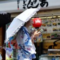 Para wanita yang mengenakan yukata, atau kimono kasual musim panas, menggunakan kipas portabel saat mereka berjalan di sepanjang Jalan Nakamise di distrik Asakusa, sebuah tempat wisata populer, karena pemerintah Jepang mengeluarkan peringatan seranga