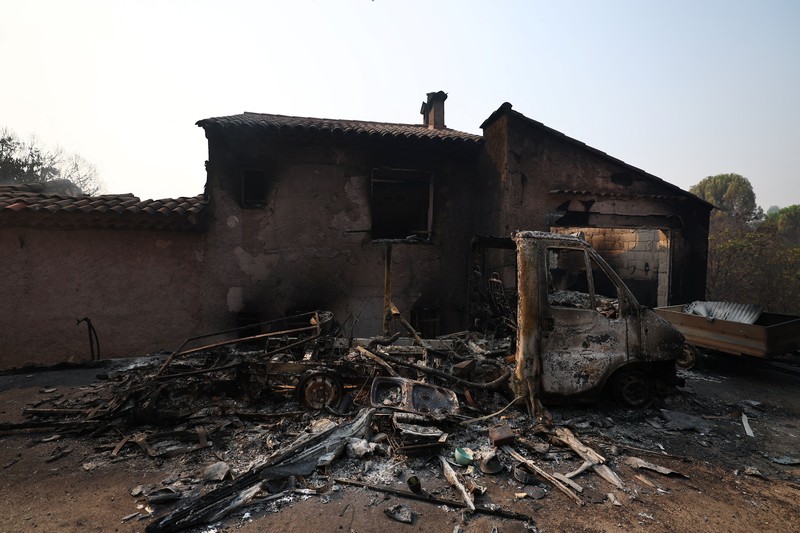 Pemandangan sebuah rumah dan sebuah van yang terbakar di daerah yang terkena dampak kebakaran hutan di Cotignac, departemen Var, saat kondisi kekeringan memburuk setelah gelombang panas dan kekurangan air di sebagian besar wilayah Prancis, 22 Juli 2026. (REUTERS/Manon Cruz)