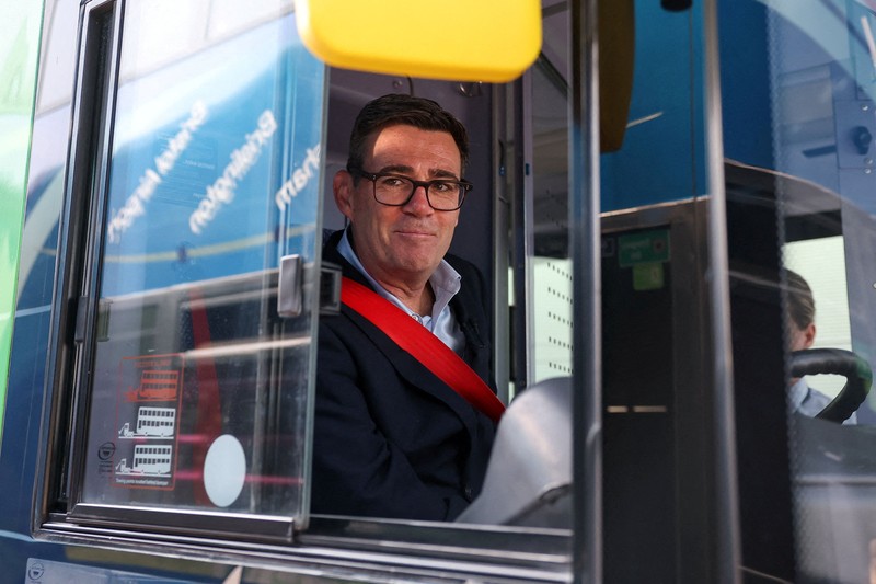 Perdana Menteri Inggris Andy Burnham bereaksi di depan bus FirstGroup di terminal bus selama wawancara di Bath, Inggris, 22 Juli 2026. (REUTERS/Toby Melville/Pool)