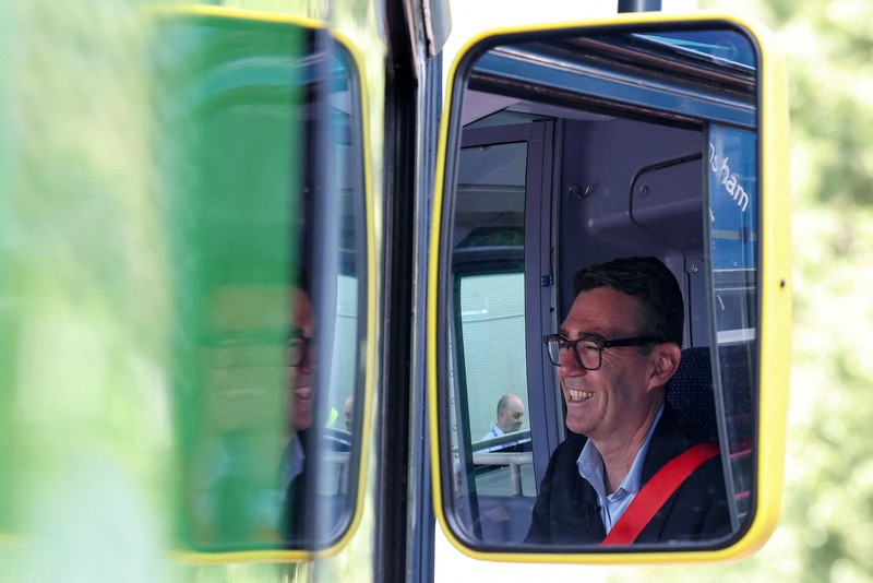 Perdana Menteri Inggris Andy Burnham bereaksi di depan bus FirstGroup di terminal bus selama wawancara di Bath, Inggris, 22 Juli 2026. (REUTERS/Toby Melville/Pool)