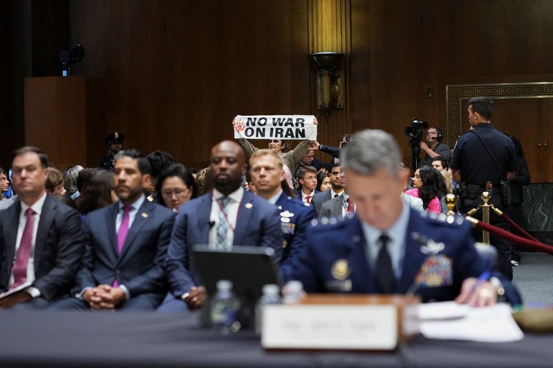 Seorang demonstran berdiri dan membentangkan poster menolak perang terhadap Iran saat sidang Komite Alokasi Anggaran Senat mengenai permintaan pendanaan tambahan Presiden AS Donald Trump untuk Departemen Pertahanan, di Washington, D.C., AS, Selasa (21/7/2026),