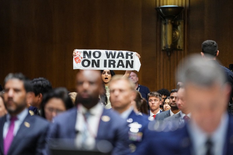 Seorang demonstran berdiri dan membentangkan poster menolak perang terhadap Iran saat sidang Komite Alokasi Anggaran Senat mengenai permintaan pendanaan tambahan Presiden AS Donald Trump untuk Departemen Pertahanan, di Washington, D.C., AS, Selasa (21/7/2026),
