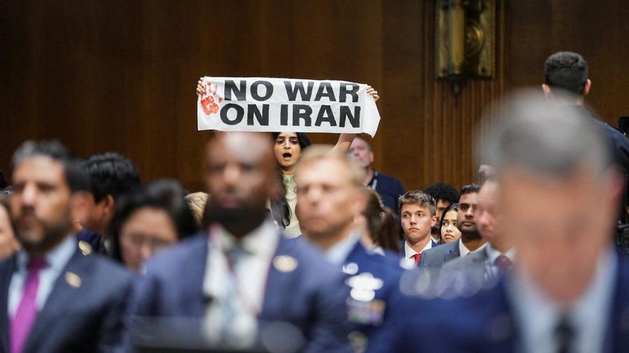 Seorang demonstran berdiri dan membentangkan poster menolak perang terhadap Iran saat sidang Komite Alokasi Anggaran Senat mengenai permintaan pendanaan tambahan Presiden AS Donald Trump untuk Departemen Pertahanan, di Washington, D.C., AS, Selasa (21/7/2026),
