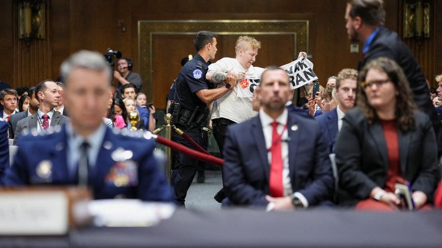 Seorang demonstran berdiri dan membentangkan poster menolak perang terhadap Iran saat sidang Komite Alokasi Anggaran Senat mengenai permintaan pendanaan tambahan Presiden AS Donald Trump untuk Departemen Pertahanan, di Washington, D.C., AS, Selasa (21/7/2026),