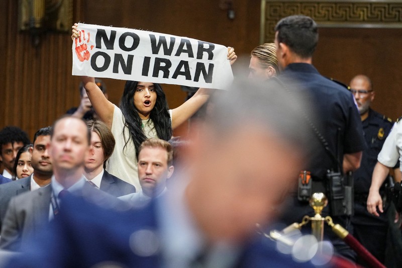 Seorang demonstran berdiri dan membentangkan poster menolak perang terhadap Iran saat sidang Komite Alokasi Anggaran Senat mengenai permintaan pendanaan tambahan Presiden AS Donald Trump untuk Departemen Pertahanan, di Washington, D.C., AS, Selasa (21/7/2026),