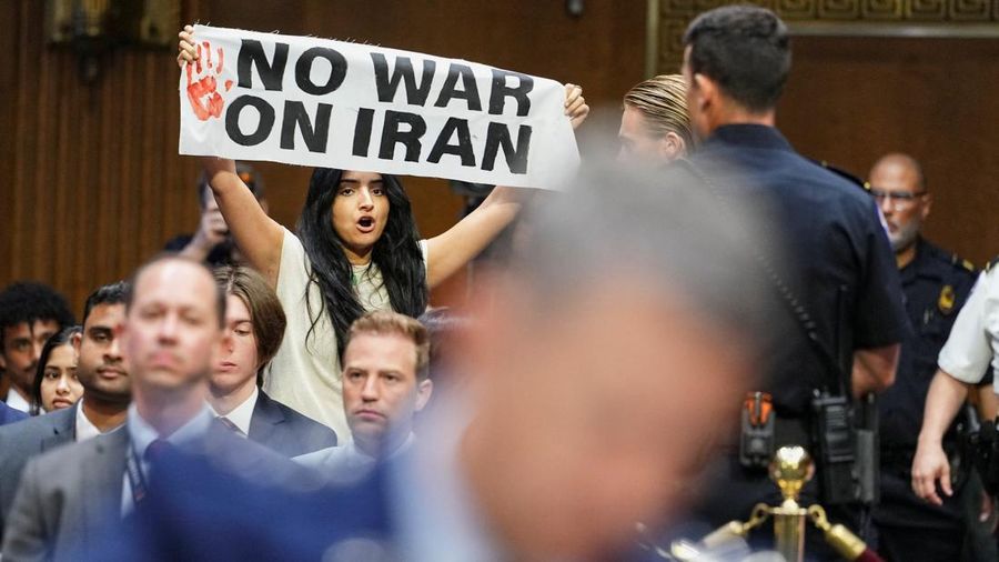 Seorang demonstran berdiri dan membentangkan poster menolak perang terhadap Iran saat sidang Komite Alokasi Anggaran Senat mengenai permintaan pendanaan tambahan Presiden AS Donald Trump untuk Departemen Pertahanan, di Washington, D.C., AS, Selasa (21/7/2026),