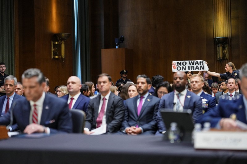 Seorang demonstran berdiri dan membentangkan poster menolak perang terhadap Iran saat sidang Komite Alokasi Anggaran Senat mengenai permintaan pendanaan tambahan Presiden AS Donald Trump untuk Departemen Pertahanan, di Washington, D.C., AS, Selasa (21/7/2026),