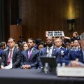 Seorang demonstran berdiri dan membentangkan poster menolak perang terhadap Iran saat sidang Komite Alokasi Anggaran Senat mengenai permintaan pendanaan tambahan Presiden AS Donald Trump untuk Departemen Pertahanan, di Washington, D.C., AS, Selasa (2