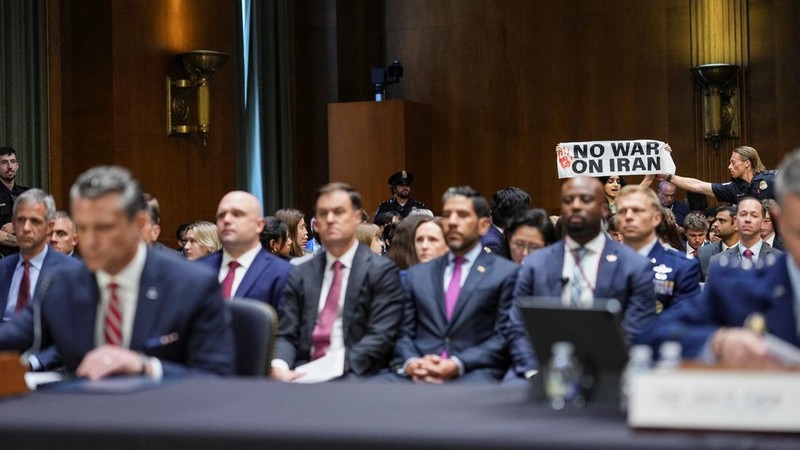 Seorang demonstran berdiri dan membentangkan poster menolak perang terhadap Iran saat sidang Komite Alokasi Anggaran Senat mengenai permintaan pendanaan tambahan Presiden AS Donald Trump untuk Departemen Pertahanan, di Washington, D.C., AS, Selasa (21/7/2026), (REUTERS/Eric Lee)