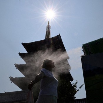 Seorang pengunjung beristirahat di dekat kabut pendingin di depan pagoda lima lantai di kuil Sensoji, tempat wisata populer, saat pemerintah Jepang mengeluarkan peringatan serangan panas di Tokyo dan prefektur lainnya karena gelombang panas, di Tokyo