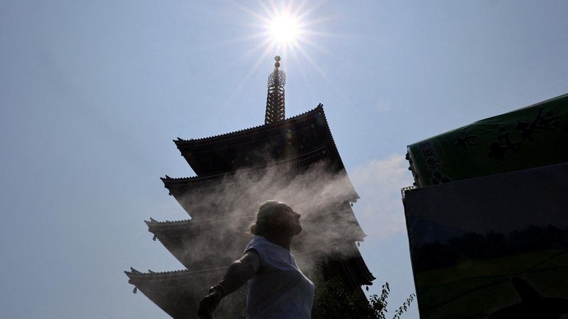 Seorang pengunjung beristirahat di dekat kabut pendingin di depan pagoda lima lantai di kuil Sensoji, tempat wisata populer, saat pemerintah Jepang mengeluarkan peringatan serangan panas di Tokyo dan prefektur lainnya karena gelombang panas, di Tokyo