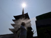 Seorang pengunjung beristirahat di dekat kabut pendingin di depan pagoda lima lantai di kuil Sensoji, tempat wisata populer, saat pemerintah Jepang mengeluarkan peringatan serangan panas di Tokyo dan prefektur lainnya karena gelombang panas, di Tokyo