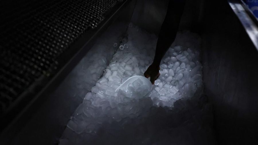 Karyawan Blue Ice, Evans Osagie, memasukkan es batu ke dalam kantong di fasilitas perusahaan selama gelombang panas di Athena, Yunani, 22 Juli 2026.
