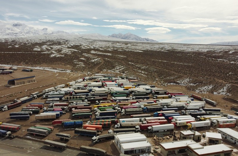 Para pengemudi truk menunggu perbatasan yang terblokir salju dibuka kembali di Uspallata, provinsi Mendoza, Argentina, Rabu (22/7/2026). (REUTERS/Maximiliano Rios)