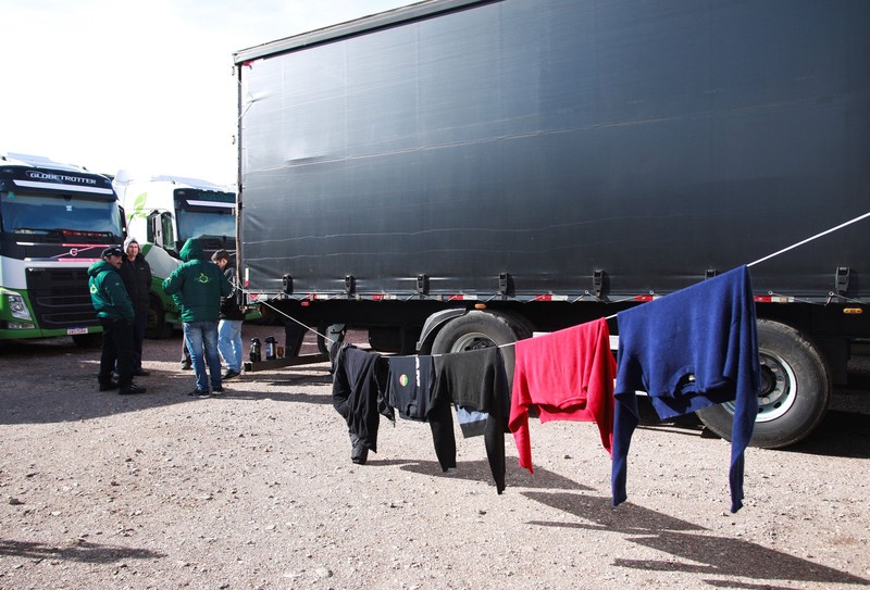 Para pengemudi truk menunggu perbatasan yang terblokir salju dibuka kembali di Uspallata, provinsi Mendoza, Argentina, Rabu (22/7/2026). (REUTERS/Maximiliano Rios)