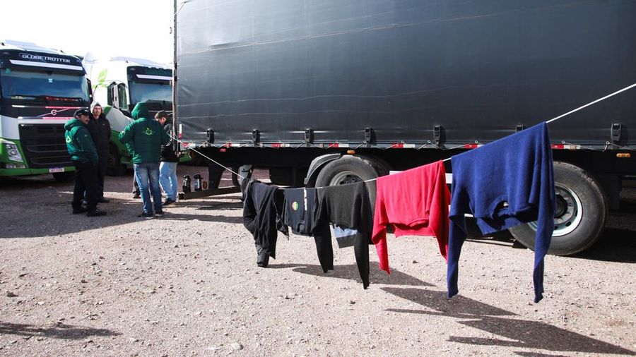 Para pengemudi truk menunggu perbatasan yang terblokir salju dibuka kembali di Uspallata, provinsi Mendoza, Argentina, Rabu (22/7/2026). (REUTERS/Maximiliano Rios)