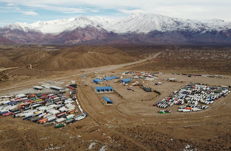 Para pengemudi truk menunggu perbatasan yang terblokir salju dibuka kembali di Uspallata, provinsi Mendoza, Argentina, Rabu (22/7/2026). (REUTERS/Maximiliano Rios)