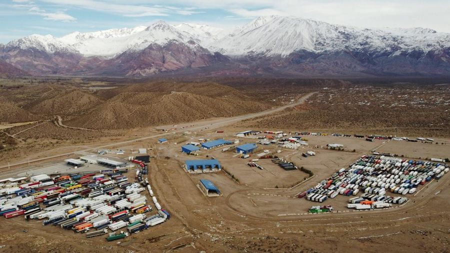 Para pengemudi truk menunggu perbatasan yang terblokir salju dibuka kembali di Uspallata, provinsi Mendoza, Argentina, Rabu (22/7/2026). (REUTERS/Maximiliano Rios)