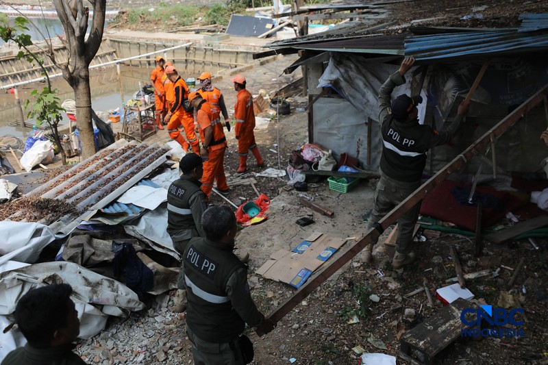Pemerintah Kota (Pemkot) Administrasi Jakarta Pusat menertibkan deretan bangunan liar dan lapak pedagang kaki lima (PKL) di sepanjang bantaran Kanal Banjir Barat (BKB) Jatipinggir, Petamburan, Tanah Abang, Kamis (23/7/2026). (CNBC Indonesia/Tri Susilo)