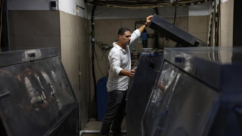 Pemilik Blue Ice, Kostas Christopoulos, memeriksa mesin pembuat es di fasilitas perusahaan selama gelombang panas di Athena, Yunani, 22 Juli 2026.