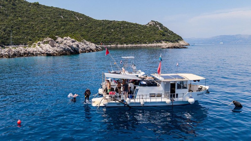 Sebuah tayangan drone menunjukkan seorang arkeolog bawah air melompat dari kapal ke lokasi ditemukannya bangkai kapal Bizantium di dekat Polace di pulau Mljet, Kroasia, 20 Juli 2026. (REUTERS/Antonio Bronic)