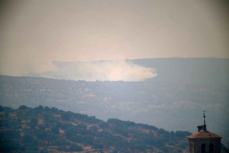 Seseorang berlari saat api menyebar di pegunungan Navaluenga, Avila, Spanyol, 23 Juli 2026. (REUTERS/Ana Beltran)
