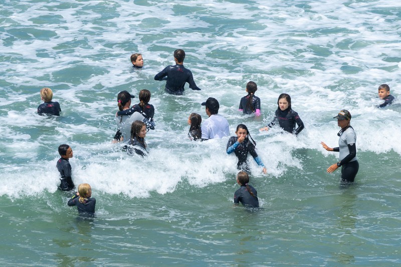 Sebuah tayangan drone memperlihatkan orang-orang menikmati air hangat di lautan sepanjang garis pantai di Encinitas, California, AS, 21 Juli 2026. (REUTERS/Mike Blake)