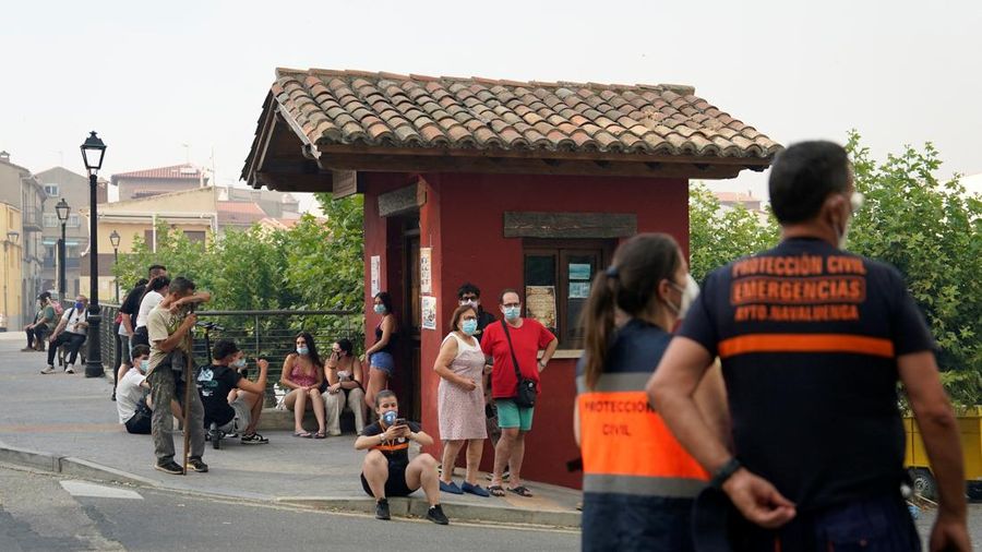 Orang-orang menyaksikan kebakaran hutan dari seberang sungai Alberche di Navaluenga, Avila, Spanyol, 23 Juli 2026.