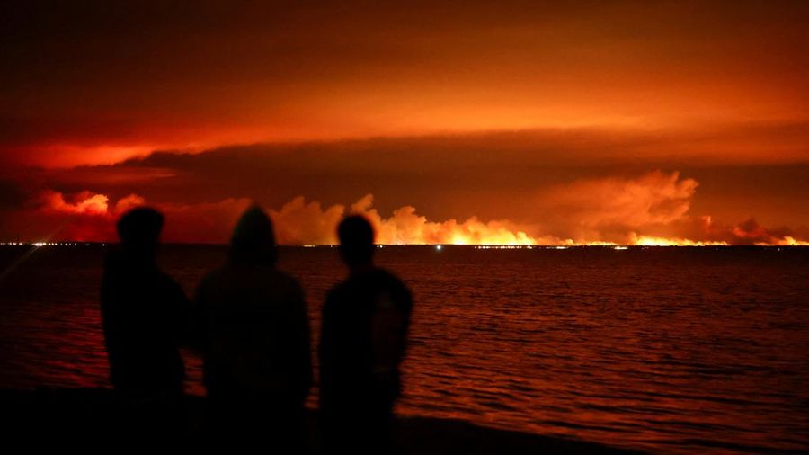 Para wisatawan menyaksikan kebakaran hutan yang melanda kawasan hutan dekat Teluk Arcachon dari Gujan-Mestras, di departemen Gironde, di tengah memburuknya kondisi kekeringan setelah gelombang panas dan kekurangan air di sebagian besar wilayah Prancis, 24 Juli 2026.