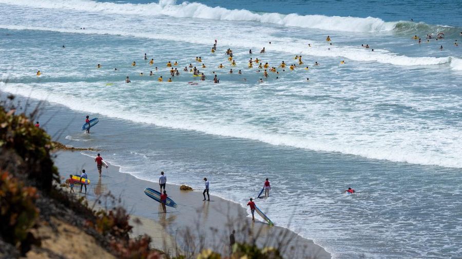 Sebuah tayangan drone memperlihatkan orang-orang menikmati air hangat di lautan sepanjang garis pantai di Encinitas, California, AS, 21 Juli 2026.
