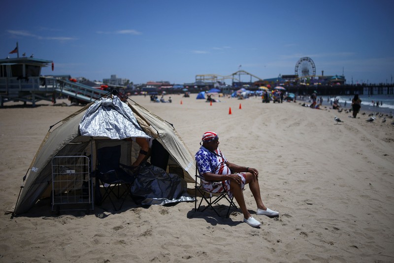 Sebuah tayangan drone memperlihatkan orang-orang menikmati air hangat di lautan sepanjang garis pantai di Encinitas, California, AS, 21 Juli 2026. (REUTERS/Mike Blake)